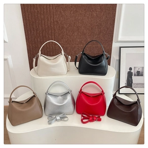 Collection of soft leather tote bags in six colors displayed on a white wave stand
