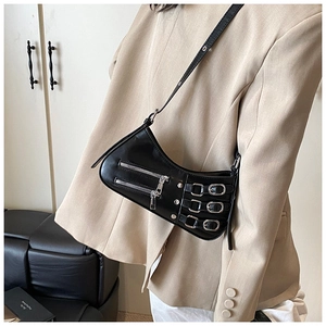 Detail of black punk Y2K bag with metal zippers and buckle straps on light blazer