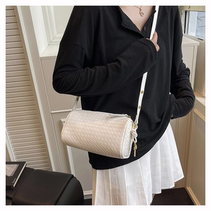 Model view of white woven cylinder crossbody bag with elegant leather knot detail
