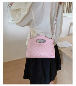 Pink quilted bag featuring rhinestones and a silver bow detail shown on a model