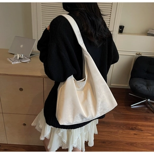 Sac hobo blanc porté dans un décor de bureau minimaliste pour le quotidien professionnel