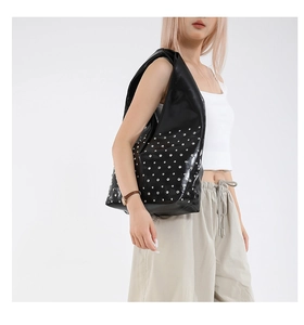 Detail of black faux leather tote with silver stud accents and wide shoulder strap