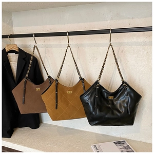 Three quilted tote bags in brown, yellow and black with chain straps and metal locks