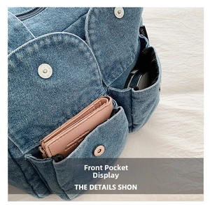 Detail of front pockets on denim crossbody bag showing storage for wallet and makeup case