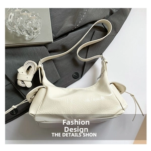 Détail du sac bandoulière en cuir plissé blanc cassé avec cordon et boucles argentées