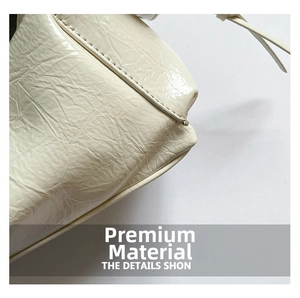 Gros plan sur le cuir verni crème brillant et les coutures de ce sac à bandoulière vintage