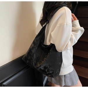 Black marble-pattern tote bag with soft texture shown on a stylish shoulder carry