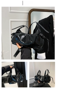 Détail du sac à bandoulière en cuir verni noir avec cordons latéraux et matériel punk