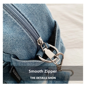 Detailed close-up of smooth metal zipper and denim stitching on the small square bag