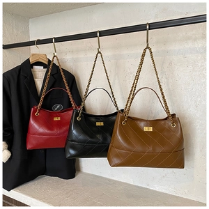 Three quilted chain bags in red black and brown hanging on a rack for daily styling