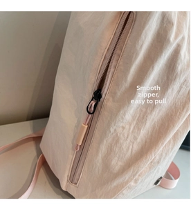Detail shot of the smooth color-matched zipper and nylon fabric texture on a travel backpack