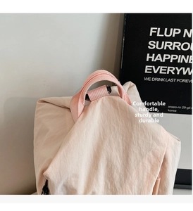 Detail of reinforced pink nylon handle on a lightweight casual student backpack