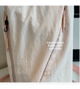 Close-up of light pink lightweight crinkled fabric and diagonal zipper on casual backpack