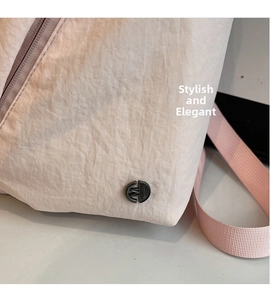 Detail of pink crinkled nylon fabric with M FASHION metal logo and woven strap