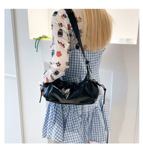 Détail du sac hobo en cuir verni noir brillant avec détails de cordon de serrage