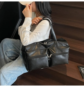 Macro view of black litchi texture PU leather travel bag with dual front zipper pockets