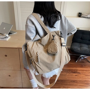 Detailed shot of khaki nylon messenger bag with wide shoulder strap and mini round pouch
