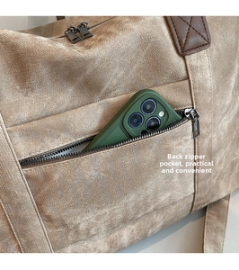Dettaglio della tasca posteriore con cerniera su una borsa beige con spazio per lo smartphone