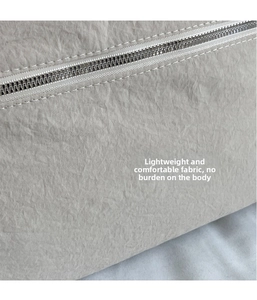 Macro view of light gray water-resistant canvas fabric with silver zipper and neat stitching