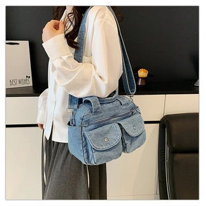 Detail of vintage blue denim small square bag showing washed fabric and metal buckles