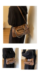 Detail einer braunen Ledertasche mit ovalem Metallgriff und silberner Gliederkette