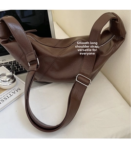 Détail d'un sac demi-lune en cuir marron avec boucle argentée dans un décor moderne