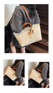 Close-up of canvas tote bag with leather handles and decorative beaded tassel charm