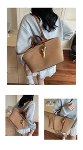 Detail of canvas tote bag featuring leather dual handles and decorative beaded tassel