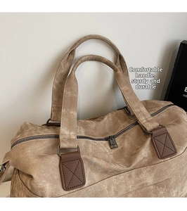 Dettaglio borsa in tela con toppe in pelle rinforzata e cerniera in metallo vintage