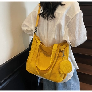 Détail du sac cabas en nylon jaune avec petite pochette et bandoulière noire réglable