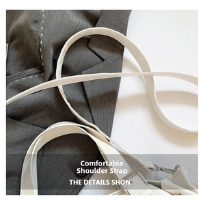 Detail showing comfortable white textured leather strap with silver buckle on travel bag