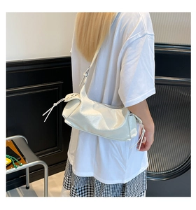 Dettaglio della borsa a tracolla plissettata bianco sporco lucido con nappa lunga sulla zip