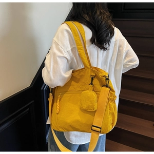 Detail of yellow waterproof canvas tote with adjustable strap and small round pouch