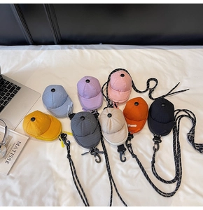 Detailed view of colorful mini baseball cap cross-body bags with textured fabric and straps