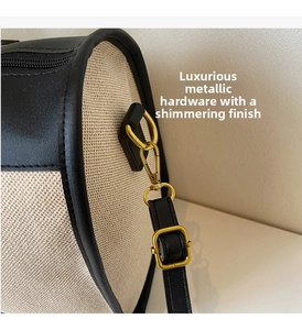 Detail of woven canvas travel bag with black leather trim and premium gold hardware