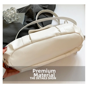 Close-up of white litchi pattern leather bag with silver metal hardware detail