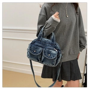 Detail of retro washed blue denim crossbody bag with dual utility pockets and metal buckles