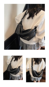 Détail montrant la large bandoulière et la texture en cuir souple du sac croissant noir élégant