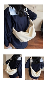Vue détaillée d'un sac hobo blanc en cuir avec large bandoulière et coutures verticales