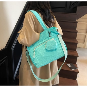 Détail du sac fourre-tout en nylon vert menthe avec poche zippée et petite pochette ronde