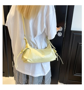 Vue détaillée du sac demi-lune jaune montrant la texture du cuir PU et les cordons