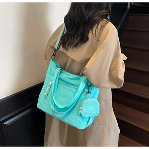 Vue arrière du sac cabas turquoise en nylon avec bandoulière et mini pochette ronde