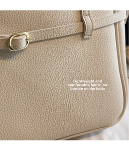Detailed macro view of beige lychee texture leather with gold metal buckle hardware