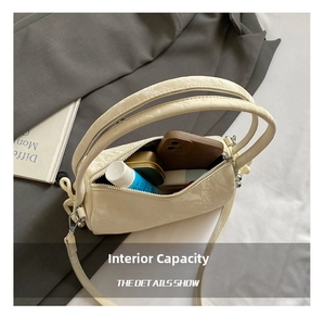 Internal capacity of the cream cylindrical bag showing phone and cosmetics