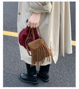 Détail du sac vintage en daim marron avec de longues franges et un rabat chic