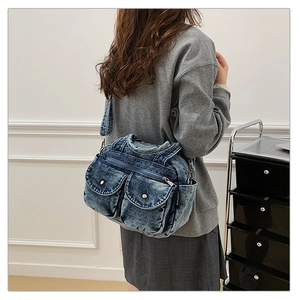 Detail of vintage blue denim crossbody bag with multi-pockets and adjustable strap
