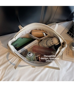 Top view of large capacity white tote bag interior with multiple everyday essentials
