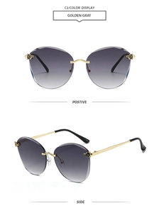 Detail view of rimless gradient gray sunglasses featuring golden panther head ornaments