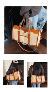 Detail of vintage canvas travel bag featuring leather handles and adjustable shoulder strap