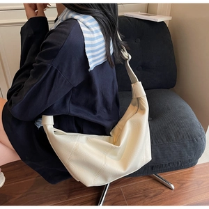 Détail du sac croissant crème montrant la texture en similicuir et les coutures de qualité